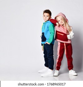 Little Bro and blonde girl in stylish jym suits standing back to back. Children athletes, sportswear fashion , togetherness, loving brother and sister. Portrait isolated on light grey, copy space - Shutterstock ID 1768965017