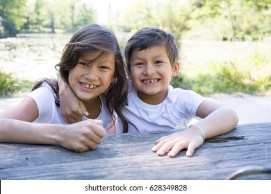 little brother and his older sister outdoor - Shutterstock ID 628349828