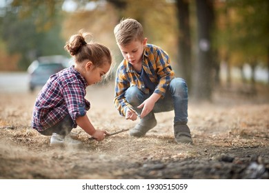 Little Brother And Sister In A Squat Playing Outdoor