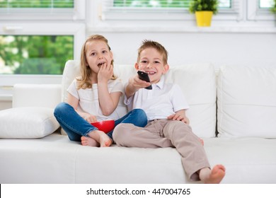 Little Brother And Sister Watching Tv On Couch