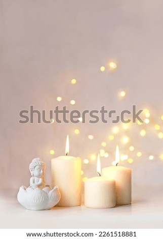 little Buddha statue and burning candles on table, abstract blurred light background. esoteric spiritual practice, Relax time, harmony, meditation. life balance concept