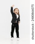 A little business girl dressed in a classic business suit on a light background shows the “Class” gesture. Concept of trust, positivity and business.