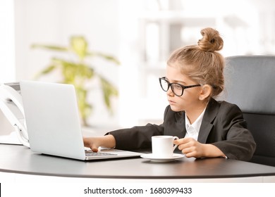 Little businesswoman with laptop working in office