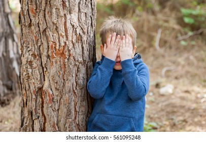 Little Caucasian Boy Closing His Face With Hands As If Playing Hide And Seek Or Scared Of Something. Hiding Face. Closed Face. Autism, Autistic Child, Aspergers, Asperger's Disorder, Autistic Boy