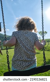 Little Caucasian Girl Alone And Sad On The Swing In The Park - Playground- Concept Of Shyness, Autism, Social Problems