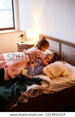 Similar – Happy boy jumping and playing over the bed with his family in a relaxed morning. Weekend family leisure time concept.