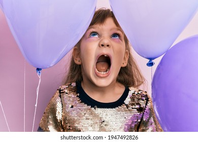 Little Caucasian Girl Kid Holding Balloons Angry And Mad Screaming Frustrated And Furious, Shouting With Anger Looking Up. 