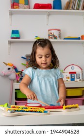 Little Caucasian Girl, In Kindergarten, Playing With A Musical Instrument, In Music Education Class.