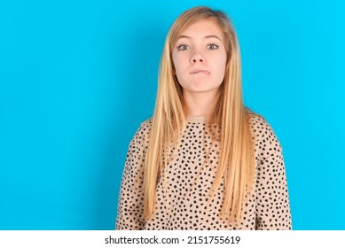 little caucasian kid girl wearing animal print sweater over blue background making grimace and crazy face, screaming out of control, funny lunatic expressing freedom and wild.