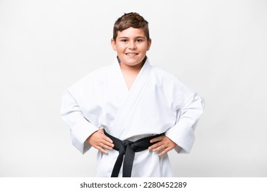 Little caucasian kid over isolated white background doing karate posing with arms at hip and smiling - Powered by Shutterstock