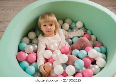 A Little Cheerful Girl Is Playing With Balloons In A Dry Pool. Top View