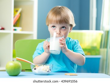 Little child boy holding glass of milk