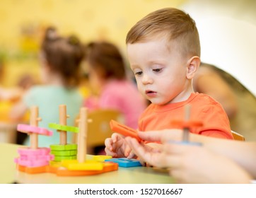 Little child boy playing with educational toy in creche or nursery