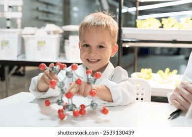 Little child boy scientists holding molecular model and learning science and chemistry in laboratory. Student learning science in classroom. Science and education concept - Powered by Shutterstock