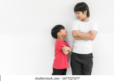 Little child boy and tall child boy standing arms crossed and looking face isolated on white background. Big and small kid concept at be friends. Back to school for concept.