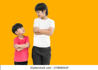 Little child boy and tall child boy standing arms crossed and looking face isolated on yellow background. Big and small kid concept at be friends. Back to school for concept.