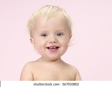 Little Child  Caucasian Baby Portrait Face Eyes Skin Teeth Closeup Blond Smiling Happy On Pink Background Studio Shot Looking At Camera 1 Year