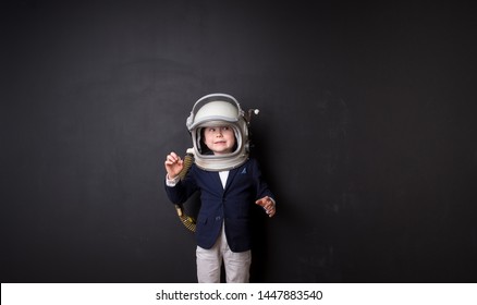 Little child dressed in astronaut helmet costume in empty room. Child autism.  Weird kid. Autistic kid go back to school. Lonely little child boy 