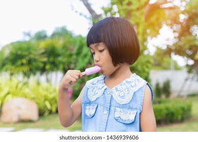 Little child eating ice cream in a park 