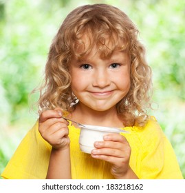 Little Child Eating Yogurt Outdoors