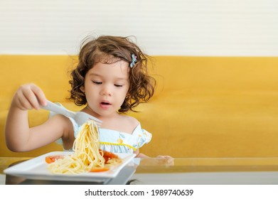 Little Child Enjoys Eating Spagetti By Herself. 