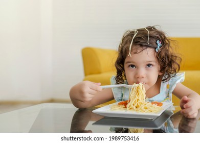 Little Child Enjoys Eating Spagetti By Herself. 