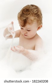 Little child exploring foam in the bath