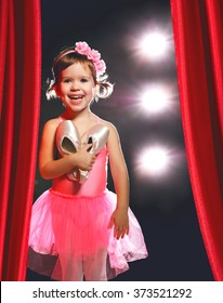 little child girl ballerina ballet dancer on the stage in red side scenes