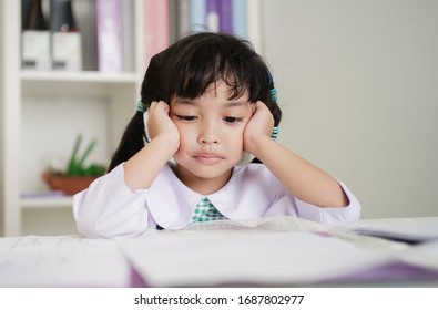 Little child girl concentrate and focusing to the homework for elementary school. thinking seriously for Educational solution concept. - Powered by Shutterstock