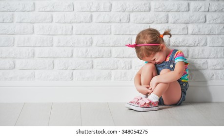 little child girl crying and sad about an empty brick wall