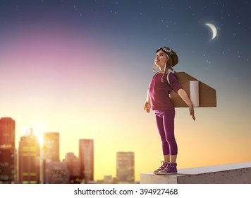 Little child girl plays astronaut. Child on the background of sunset sky. Child in an astronaut costume plays and dreams of becoming a spaceman. - Powered by Shutterstock