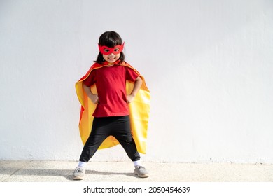 Little child girl plays superhero. Child on the white background. Girl power concept - Powered by Shutterstock