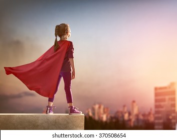 Little child girl plays superhero. Child on the background of sunset sky. Girl power concept - Shutterstock ID 370508654