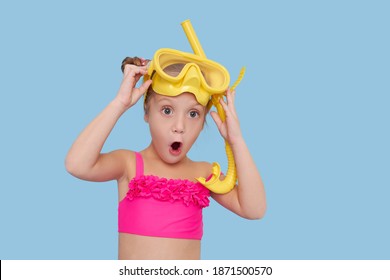 Little Child Girl In Scuba Mask And Snorkel On Blue Background. Funny Face, Wow Emotions. Summer Vacation Concept