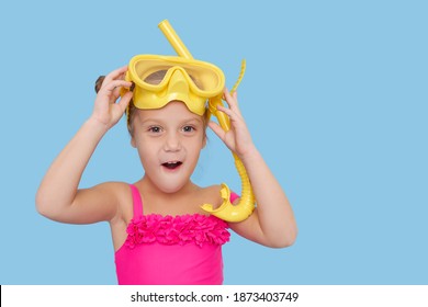 Little Child Girl In Scuba Mask And Snorkel On Blue Background. Funny Face, Wow Emotions. Summer Vacation Concept