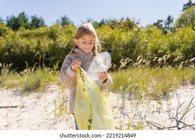 Little Child Girl Sorting Plastic Bottle Into The Trash Bag At The Beach. Ecology And Environment Concept.