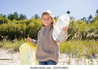 Little Child Girl Sorting Plastic Bottle Into The Trash Bag At The Beach. Ecology And Environment Concept.