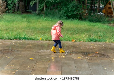 Little Child Girl Walking In The Rain In Rainboots