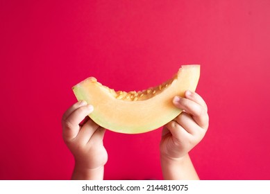 Little child hand holding a honeydew melon or rockmelon against pink background. Concept of healthy eating and agriculture - Shutterstock ID 2144819075