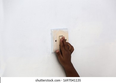 Little Child Hand Turning On The Light With A Wall Switch