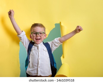 Little child hero breaking through yellow paper wall. Happy smiling kid in glasses ready for education. Success, motivation concept. Back to school. Pupil with bag on first day of fall. Boy superhero. - Shutterstock ID 1461039518