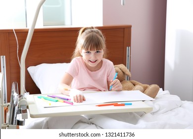 Little Child With Intravenous Drip Drawing In Hospital Bed