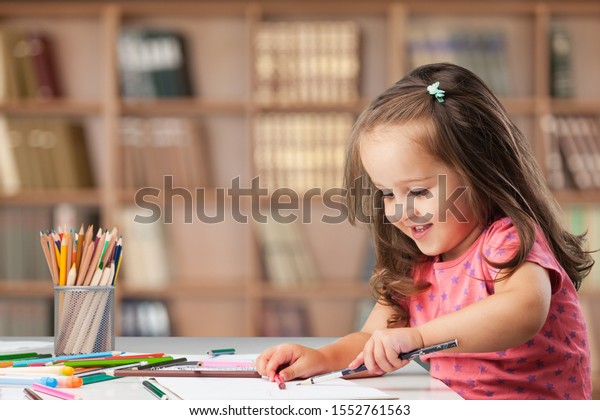 Little child kid writing and drawing on a table.\
Preschooler. Early learning. Kindergarten homework. Homeschooler\
art class.