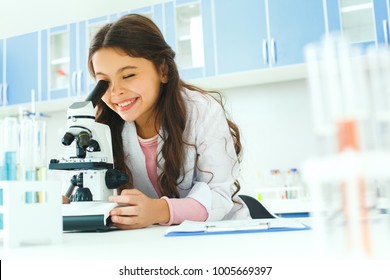 Little child with learning class in school laboratory using microscope - Powered by Shutterstock