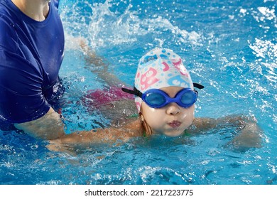 Little child learning to swim in pool with teacher - Powered by Shutterstock