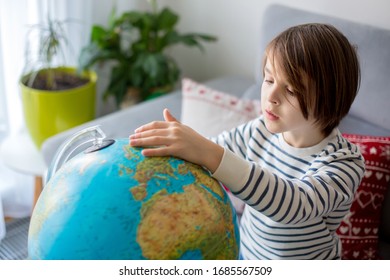 Little child, looking at illuminated globe, exploring the world, learning - Powered by Shutterstock