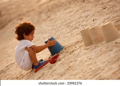 Little Child Making Sand Castles At The Beach