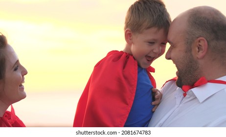 Little Child With Mother And Father Playing Superheroes Dressed In Red Cloaks, Happy Family, Brave Savior Costume, Fantastic Childhood Dream Heroes, Fearless Kid Boy Winner, Fun To Play The Game