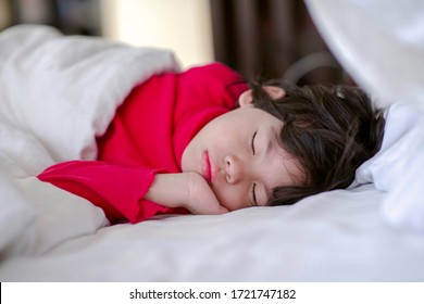 Little Child Napping.Boy Sleeping On Bed With White Bedsheet And Comforter.Preschooler Nap Time.Cute Asian Young Male With Eyes Closed Lying Down On Mattress In The Morning.