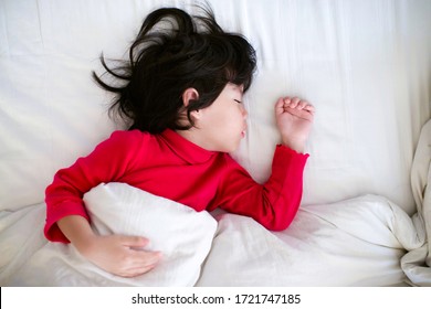 Little Child Napping.Boy Sleeping On Bed With White Bedsheet And Comforter.Preschooler Nap Time.Cute Asian Young Male With Eyes Closed Lying Down On Mattress In The Morning.